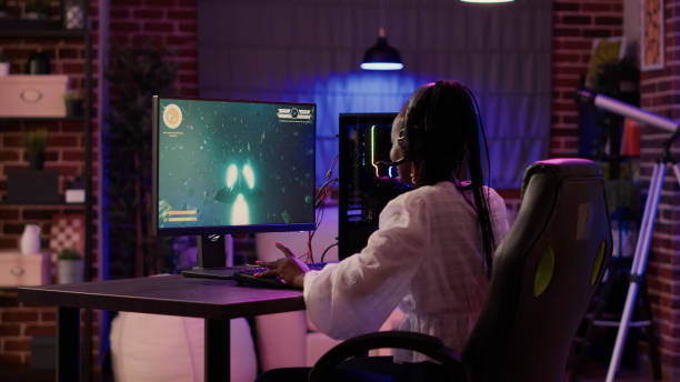 istock Woman playing multiplayer space shooter simulation enjoying free time using pc gaming setup 1441838562