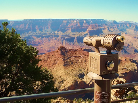 Flagstaff, United States – May 09, 2004: A coin-operated telescope with the scenic Grand Canyon National Park view in the background