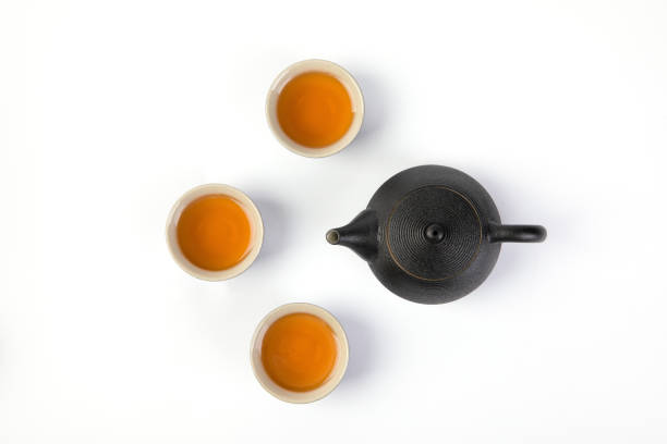 istock Top of a black teapot with three teacups isolated on white background 1441839942