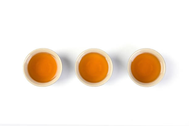 istock Overhead shot of poured black tea on three teacups isolated on white background 1441839945