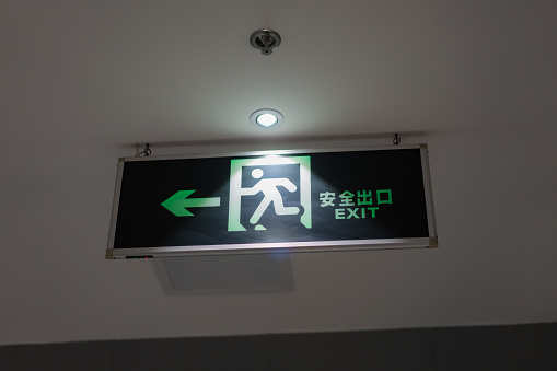 Fire emergency exit sign on a white wall.