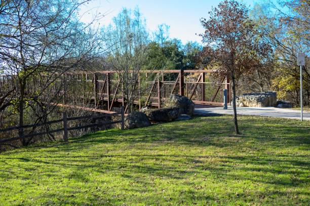istock Old bridge surrounded by autumn trees in a park on a sunny day 1441840210