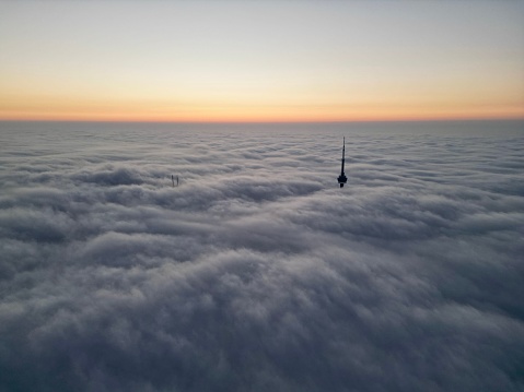 Toronto, Canada – November 02, 2022: A beautiful view of A cityscape with the CN Tower in dense fog in Toronto with sunset sky