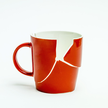 A broken red mug isolated on a white background
