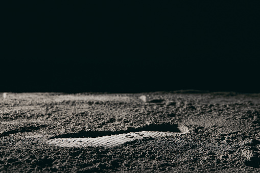 A footprint on the moon against a black background