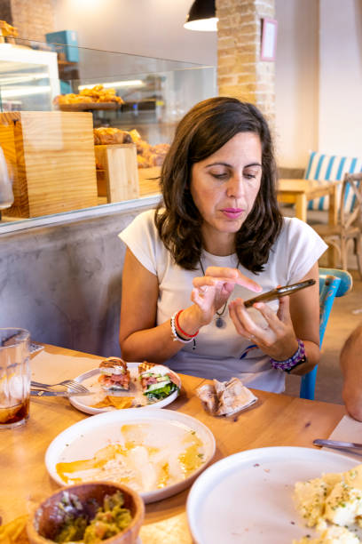istock Woman sitting at restaurant using cell phone to send text 1441844059