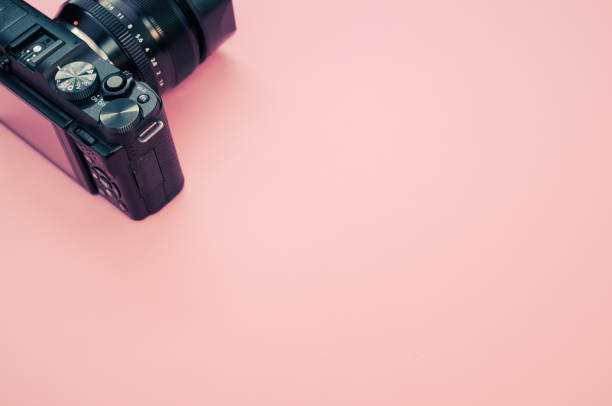 istock Closeup of a camera on a pastel pink surface for a copy space 1441844078