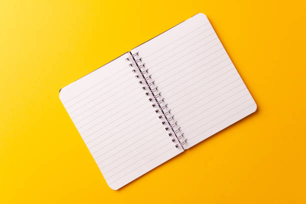 istock Top view of an open journal isolated on a yellow background 1441844612