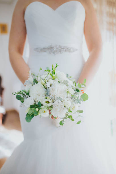 istock Elegant bride posing with a white wedding bouquet 1441845028