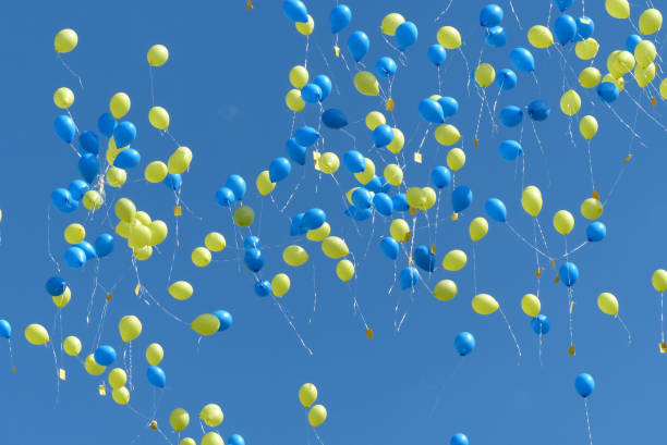 Yellow and blue balloons flying in the blue sky