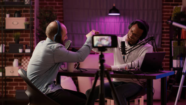 istock Static tripod shot of internet radio host recording podcast using digital video camera greeting guest 1441846650