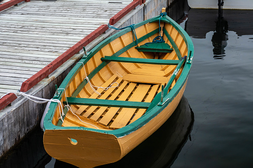 Small yellow and green dory tied up at a dock, Trinity, Newfoundland.