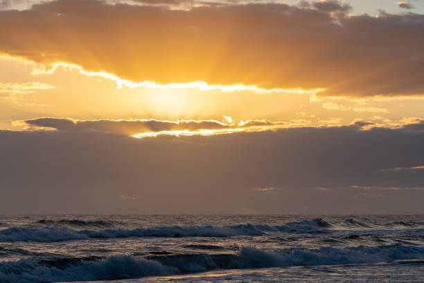 istock Beautiful shot of ocean waves at sunset 1441847076