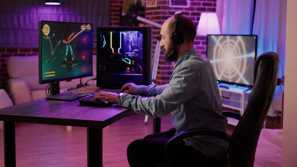istock Gamer playing fast paced space shooter simulation screaming victorious at the computer screen after winning 1441847195