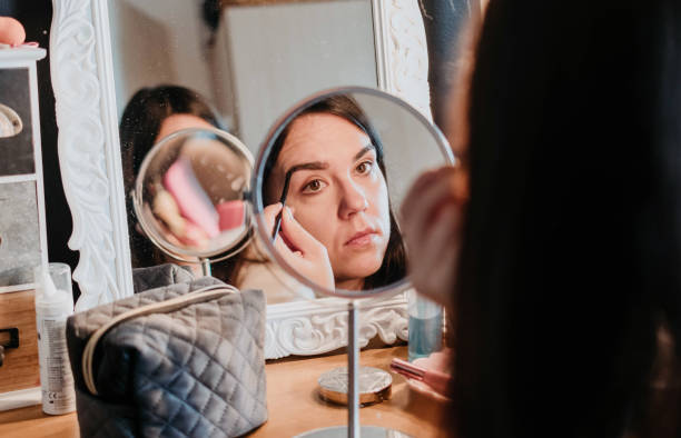 istock Closeup of a female doing her eyebrows while looking into a small mirror 1441847410