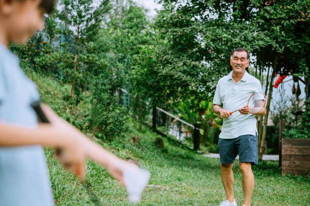 Asian little girl learning badminton from grandfather Badminton - Sport, Senior Adult, Males, Playing, Senior Men chinese badminton stock pictures, royalty-free photos & images