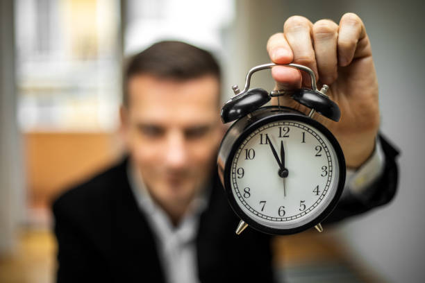 istock Businessman holding an alarm clock 1441848728