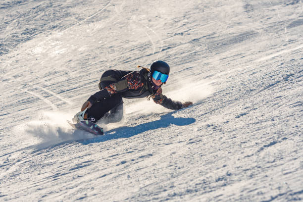 Closeup of a female snowboarder in motion on a snowboard in a mountain A closeup of a female snowboarder in motion on a snowboard in a mountain snowboarding snowboard women snow stock pictures, royalty-free photos & images
