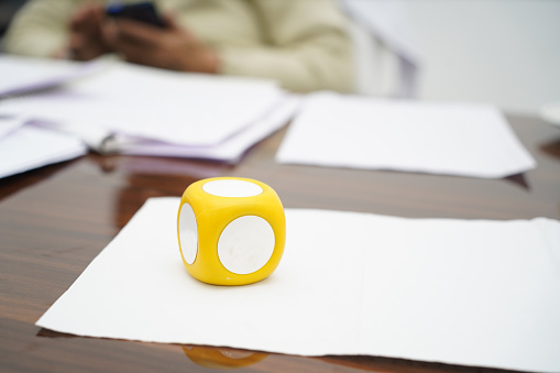 A selective focus closeup of a paperweight over a paper on a wooden office table