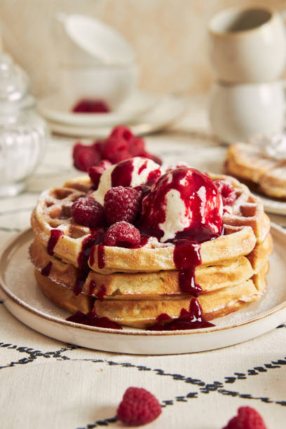 istock Delicious waffles with vanilla ice cream, strawberries and raspberries on a breakfast table 1441852196