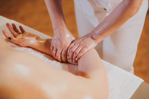 A closeup of a masseuse massaging a caucasian woman in the spa