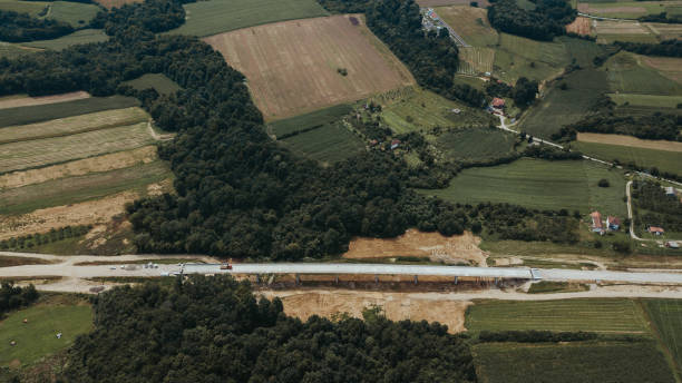 istock Aerial shot of a road under construction surrounded by cultivated fields in Brcko district 1441853837