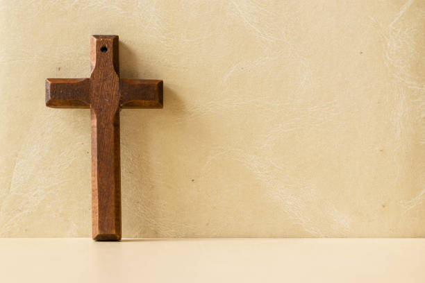 istock Wooden cross on a yellow background with space 1441854278
