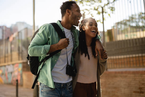 abrazado sonriente pareja afroamericana con una cámara visita la ciudad - town of progress fotografías e imágenes de stock