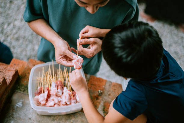 padre e figlio asiatici che preparano il cibo per la loro nuova attività - meat raw beef love foto e immagini stock