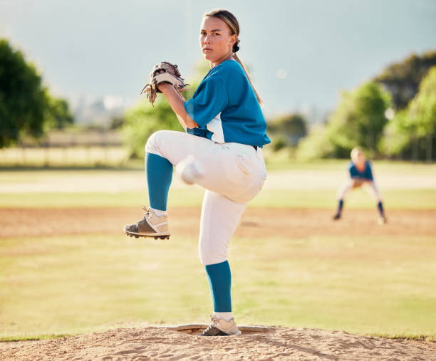baseball pitcher, ball sports and a athlete woman ready to throw and pitch during a competitive game or match on a court. fitness, workout and exercise with a female player training outside on field - playing field determination exercising relaxation exercise imagens e fotografias de stock