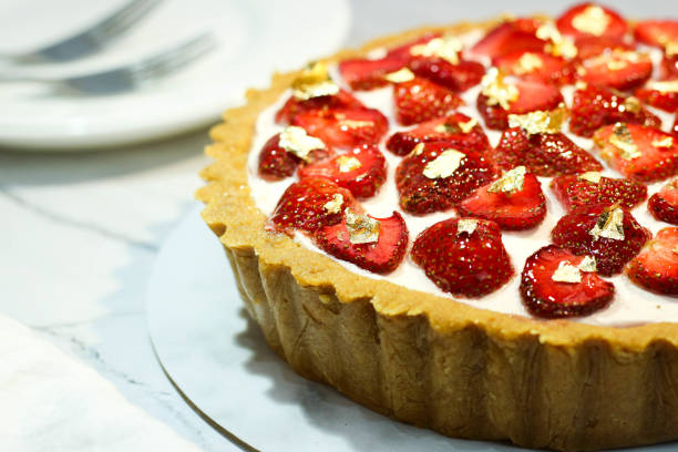 homemade strawberry pie with cream and strawberries as a topping on white plate on the table table. delicious fruit pie. strawberry cake. food photography concept