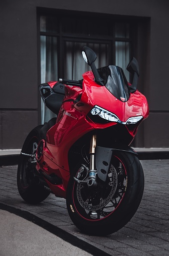 Sliver spring, United States – November 15, 2022: A closeup shot of a red motorcycle Ducati Panigale 1199, parked on the street, with a building in the background