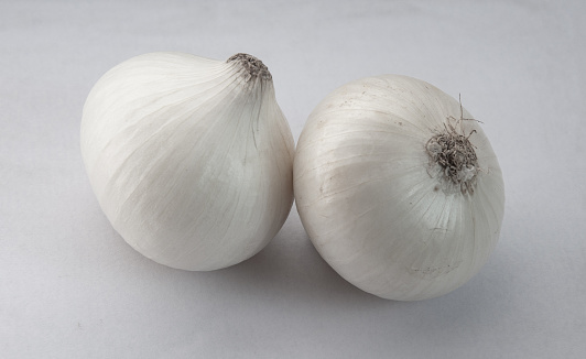 Two heads of white onion on a white background