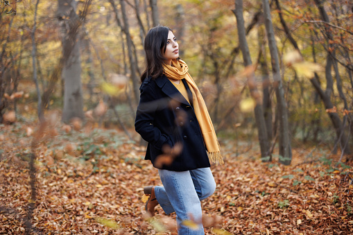Young woman enjoying relaxing walk in beautiful autumn nature