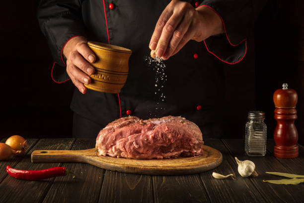 istock The chef sprinkles raw meat with salt. Preparing fresh meat before roasting. Menu concept for restaurant or hotel. Asian cuisine 1441866895