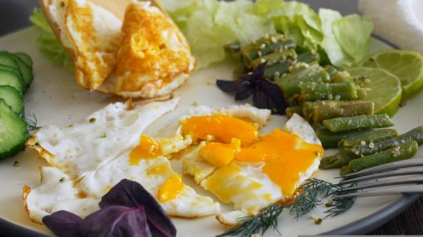 istock Fried eggs with stewed vegetables and herbs are tasty and nutritious. Breakfast on keto diet is high in fat and protein. Proper nutrition in morning is the key to health and energy for the whole day. 1441866908