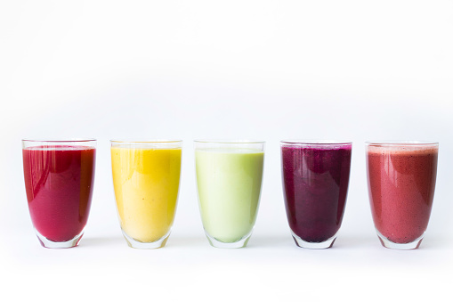 Variety of rainbow coloured fruit smoothies or juice