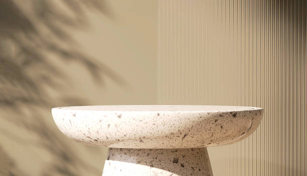 istock Modern, minimal round white granite stone table podium with reeded glass partition in dappled sunlight and leaf shadow on beige brown colored wall 1441871321