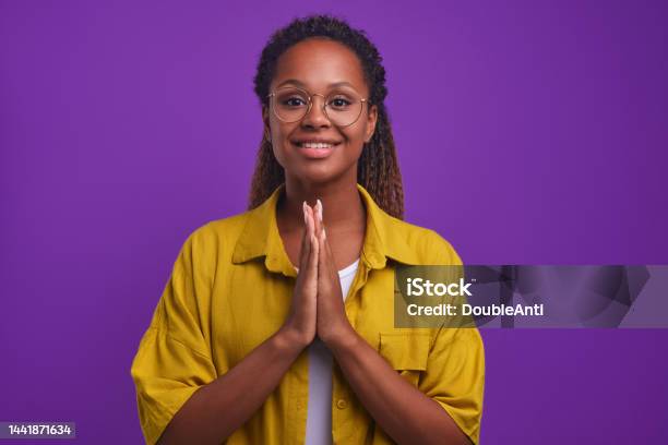 Young Sweet Goodnatured African American Woman Prayer Stands In Studio Stock Photo - Download Image Now