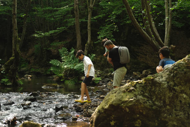 istock Father with son exploring river in a tropical forest. 1441872288
