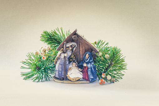 a depiction of the holy family, saint joseph, the virgin mary and the child jesus, on a gray wooden surface, against a black background, in a panoramic format to use as web banner