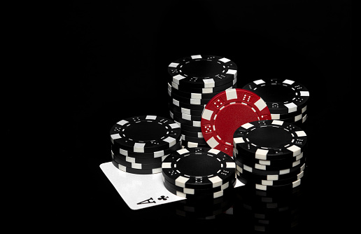 Top view of golden 100 dollar playing cards next to stacks of chips on red felt table. Poker game is one of the most popular card games in the world and played
