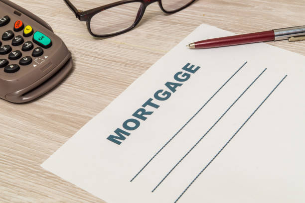 istock Mortgage agreement form with pen and glasses on table 1441873529