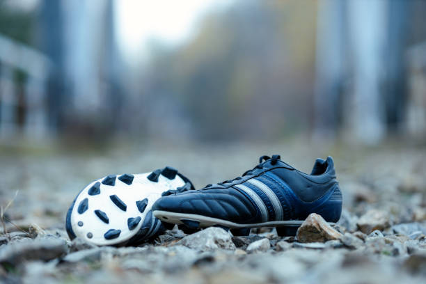 Soccer shoes lying down outside.