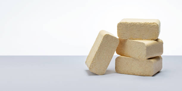 istock pressed sawdust fuel briquettes on grey background. banner with copy space. 1441873867