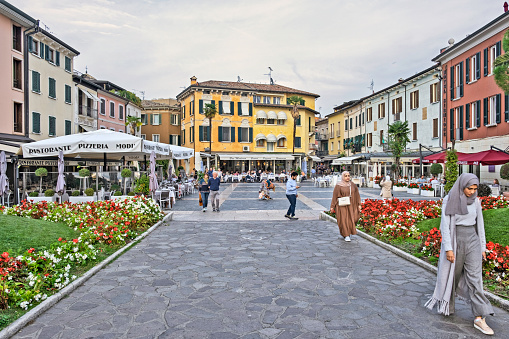 Sirmione, Italy - October 13, 2022: View of the  Piazza Giosuè Carducci with pedestrians and local architecture in Sirmione, Italy.