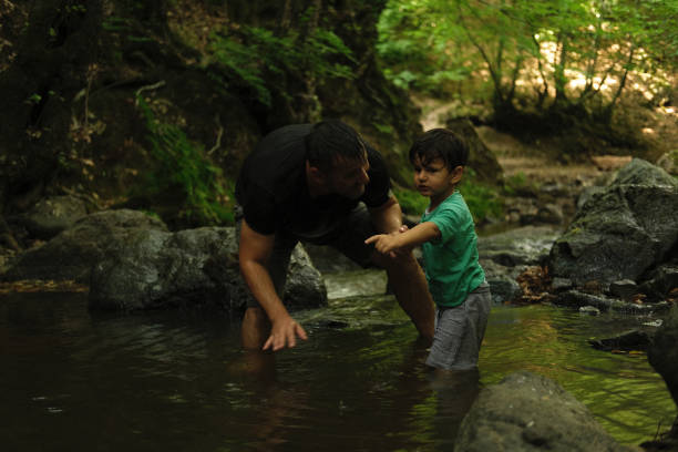 istock Father with son exploring river in a tropical forest. 1441874967