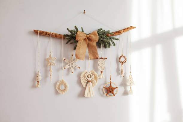 Christmas macrame decor. Christmas snowflake and decorative elements on wooden stick. Natural materials - cotton thread, wood beads. Eco decorations, ornaments, hand made decor. Copy space stock photo