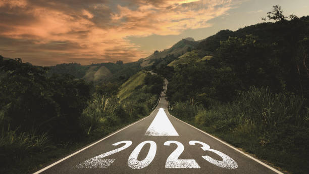 New year 2023 or straight forward concept. Text 2023 written on the road in the middle of asphalt road with at sunset. Concept of planning, goal, challenge, new year resolution. stock photo
