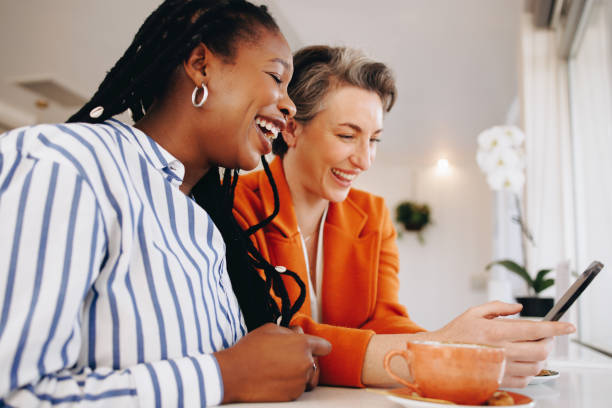 istock Business women using a smartphone together in a coffee shop 1441876540